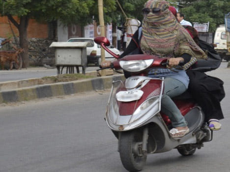 Why are women in Delhi helmet cut short?
