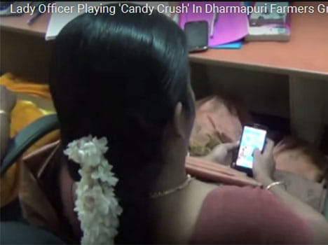 lady officer playing candy crush game at farmer meeting