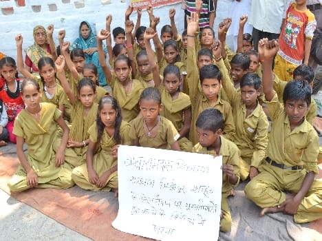 School children sit on protest