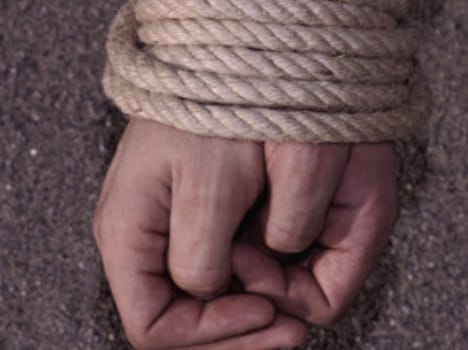 woman is tied to a pole and brutally beaten.