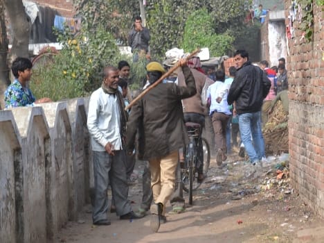 There policeman chasing a crowd of supporters