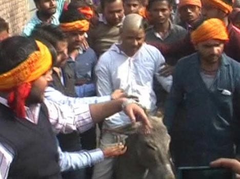 shaved head of accused of Conversion and rotated in town
